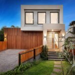 Modernes Einfamilienhaus mit Holzfassade und Garten bei Abendlicht