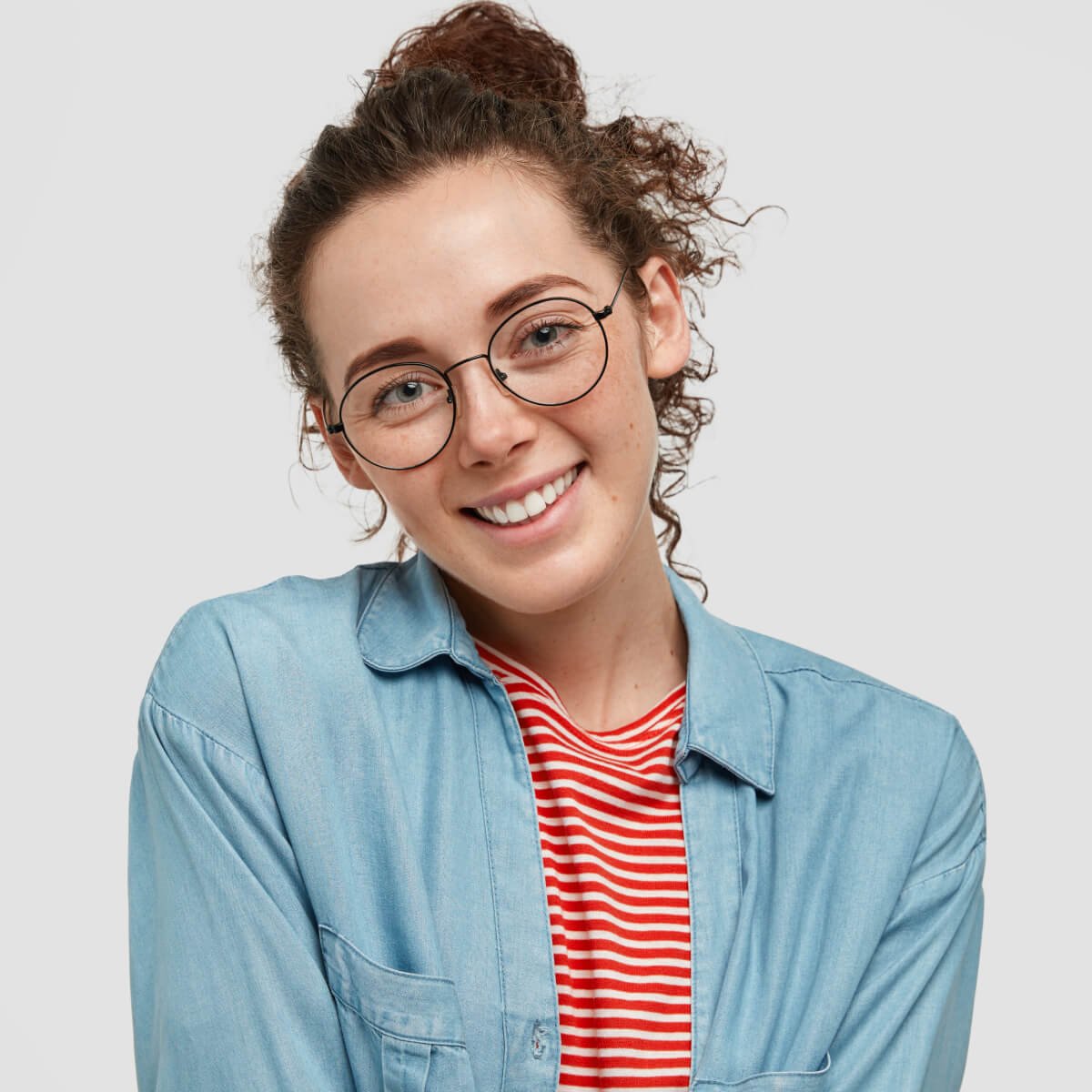 Freundliche junge Frau mit Brille und Locken